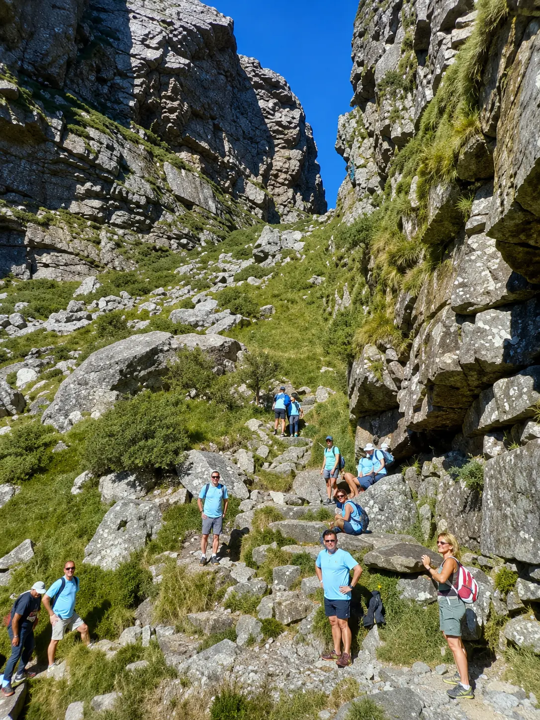 Hikers climbing a rugged rocky gorge on a Table Mountain hiking trail in Cape Town.
