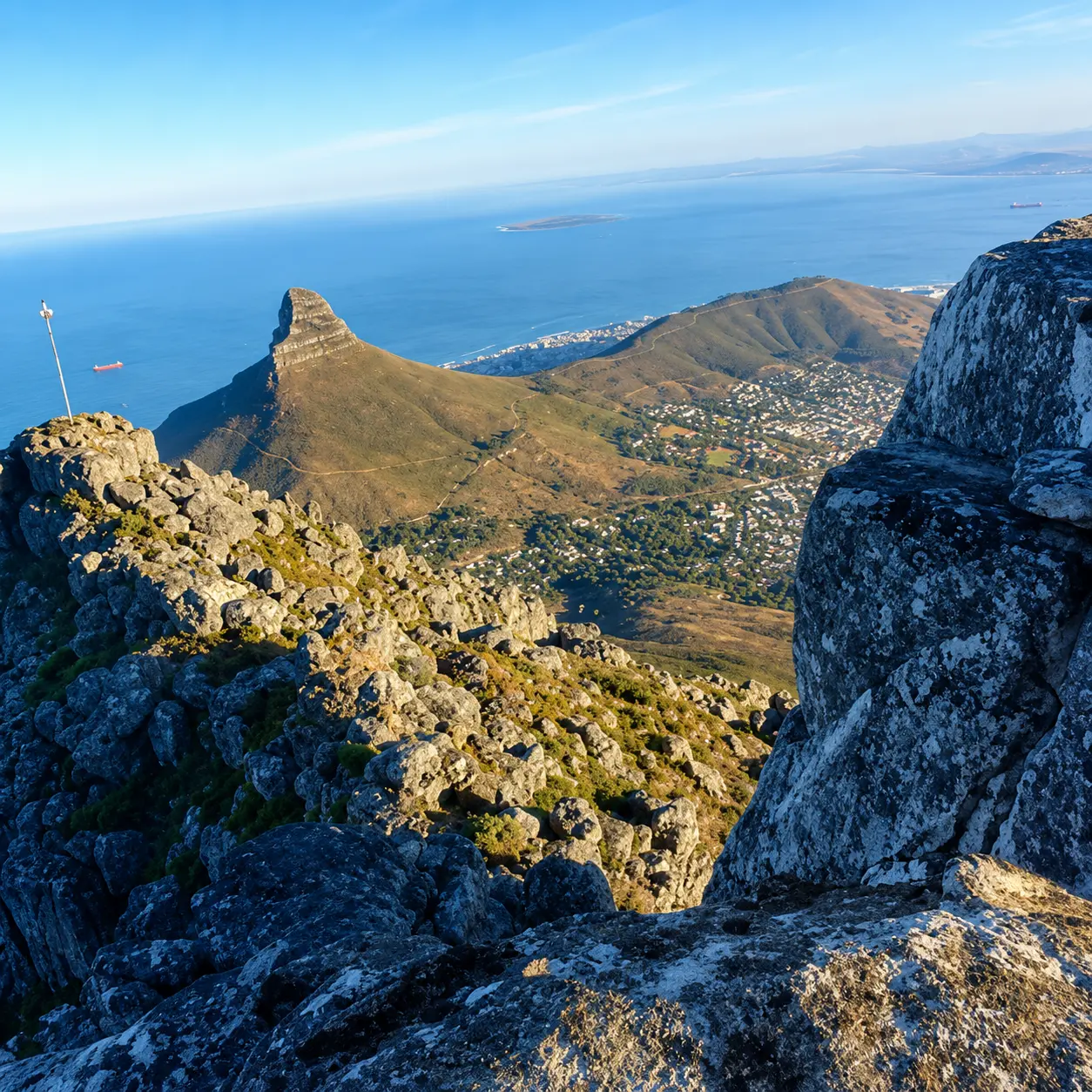 Panoramic view of Lion’s Head, Cape Town, Table Bay and the Atlantic Ocean from a rocky viewpoint on Table Mountain.